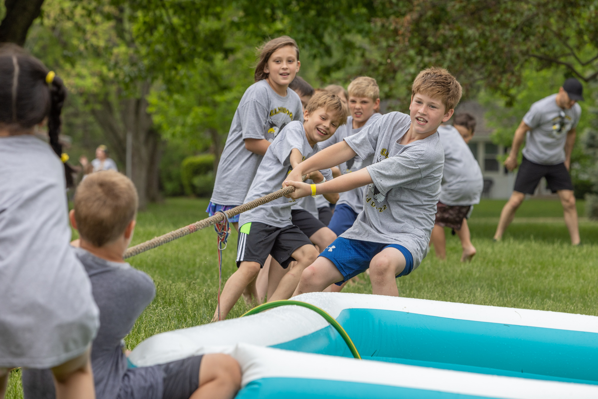 Elmwood students in matching grey Field Day shirts engaging in a game of tug of war